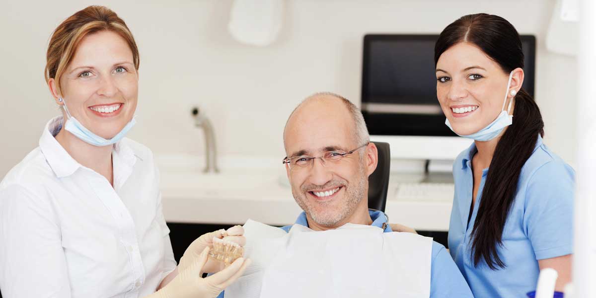 Happy Old Patient with two Dentistes